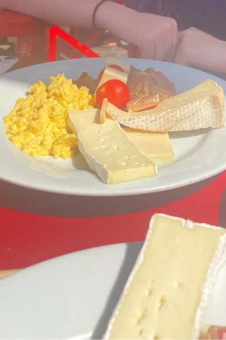 Plate full of scrambled egg, cheeses and more served in Cassis France