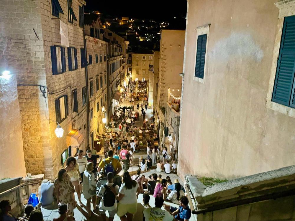A summer night on Dubrovnik’s Jesuit Stairs, packed with people hanging out on the stairs and soaking up the atmosphere