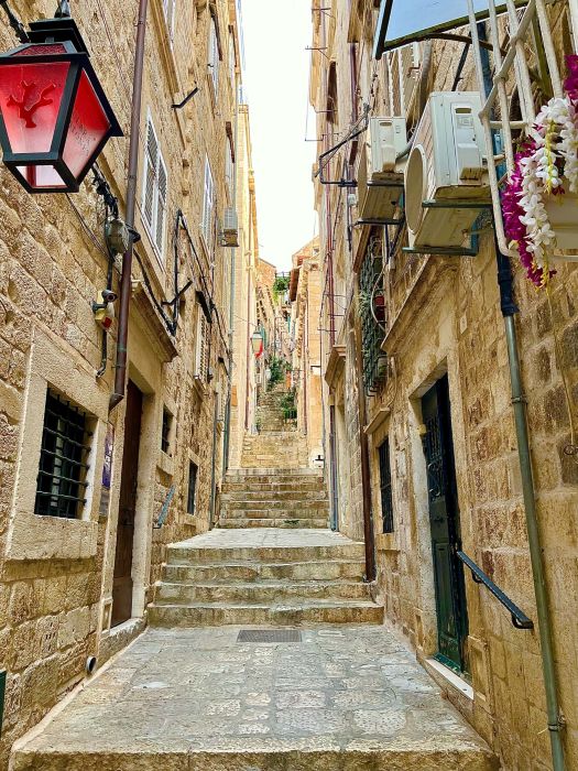 A stone alleyway in Dubrovnik’s Old Town, with steps leading up. 